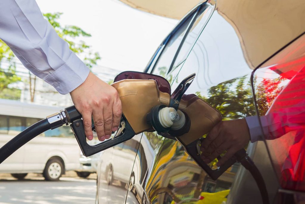 Hombre recargando gasolina en su vehículo en una gasolinera