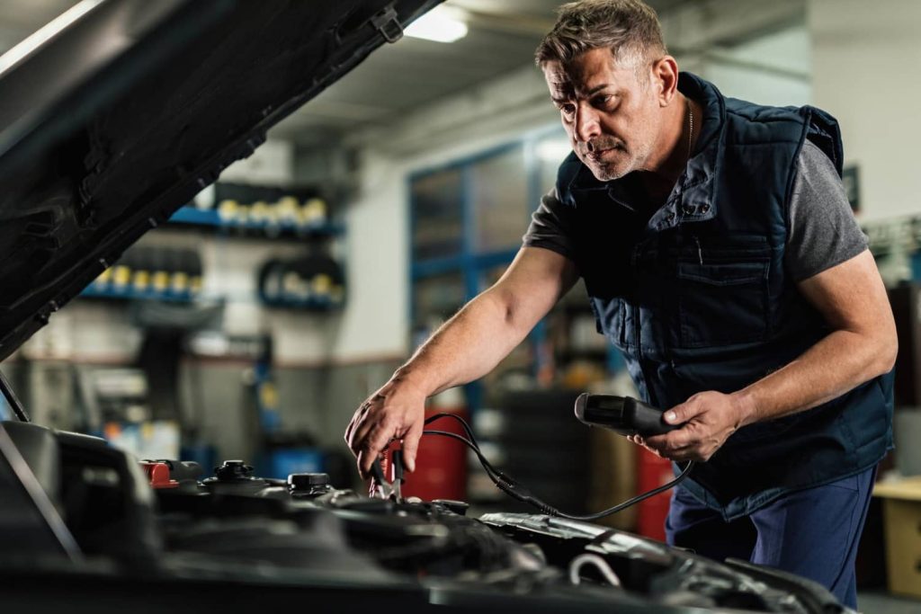 Hombre revisando el voltaje de la batería de auto