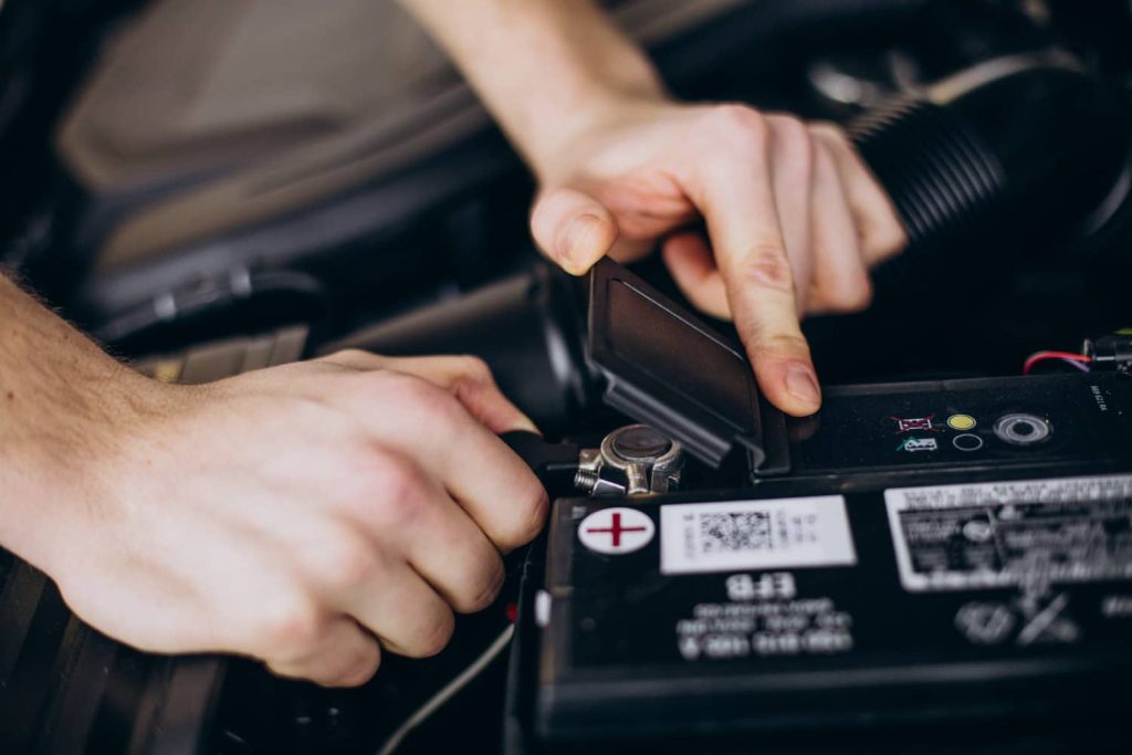 Manos señalando la batería de carro